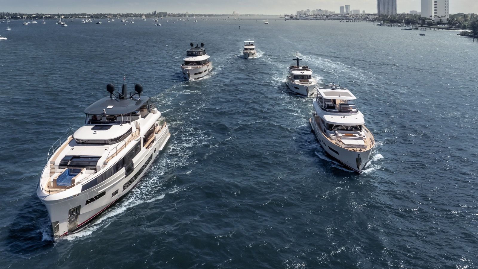 Aerial view of four yachts underway over Miami — the caliber of vessel Three Marine crew manage